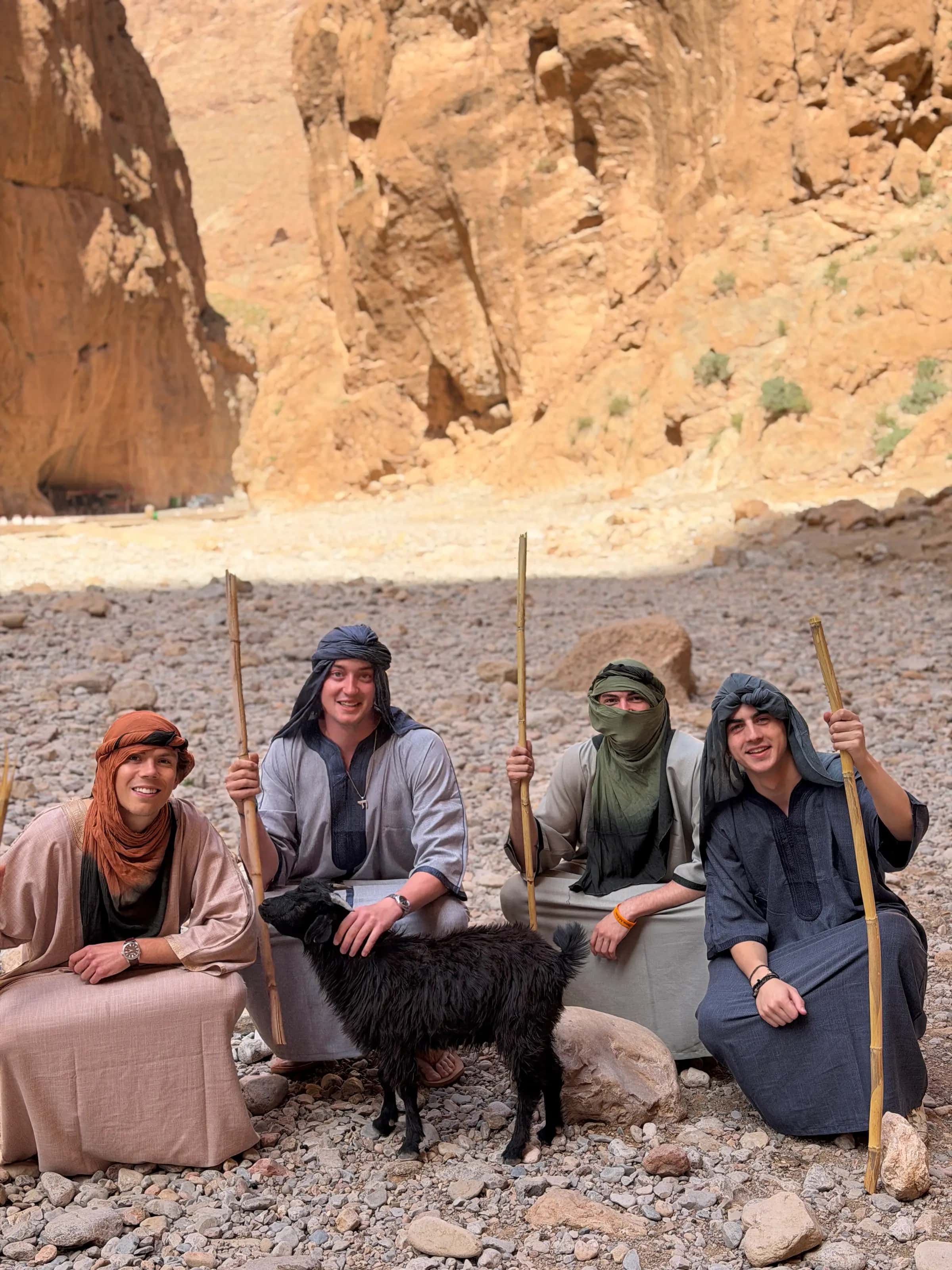 Travellers in desert dress sitting together in a gorge